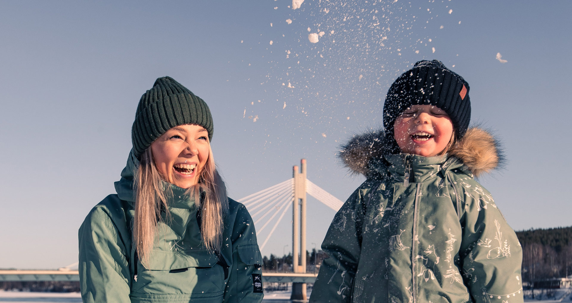 Äiti ja lapsi leikkivät lumessa Kemijoen rannalla lähellä Jätkänkynttilää.